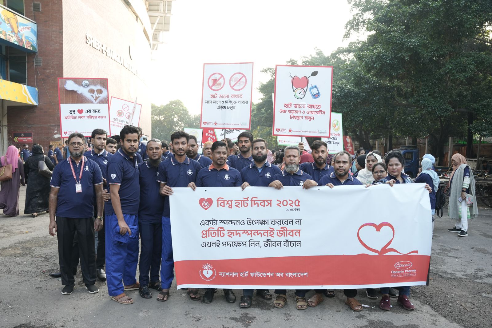 The rally sets off behind the World Heart Day banner.